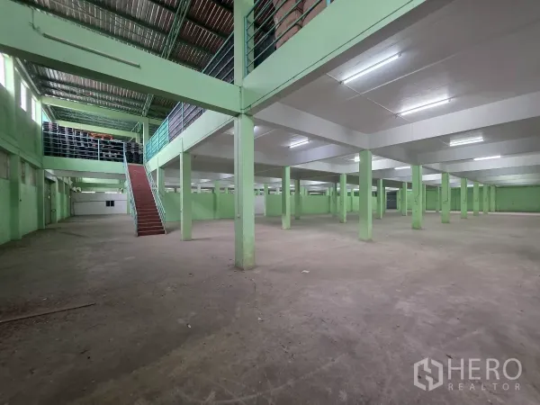 货栈 出租在Bang Khun Thian, Bangkok - 开阔仓库内部，混凝土地面，通往夹层的楼梯与多排立柱