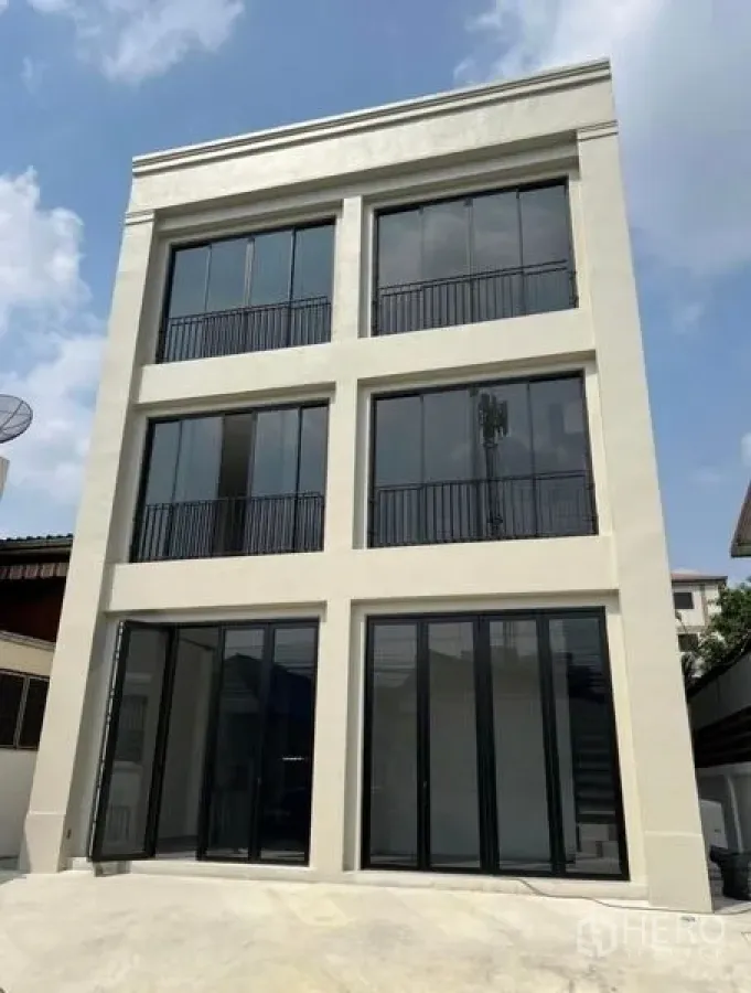 Home Office for rent or sale in Bang Na, Bangkok - Modern three-storey home office exterior in Bang Na with tall black-framed windows and balconies.