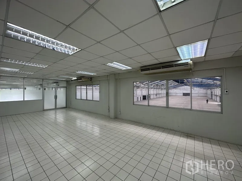 Factory for rent in Nonthaburi - Air-conditioned office overlooking the production floor through large windows.