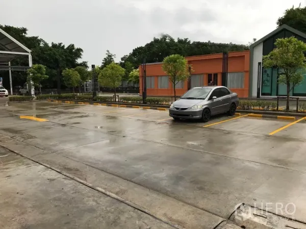 Retail Space for rent in Bang Na, Bangkok - On-site surface parking with marked bays and landscaped trees at the retail complex.