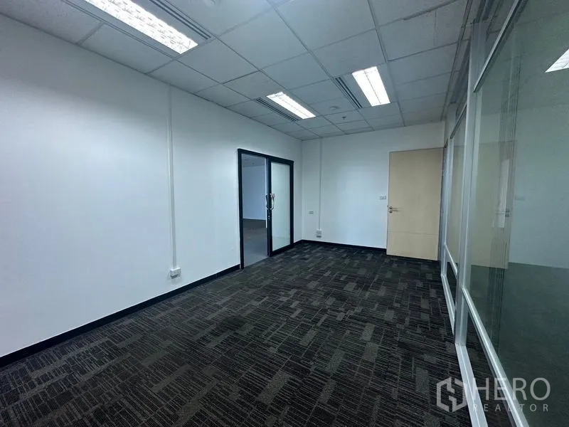Office Space for rent in Khlong Toei, Bangkok - Mid-size office with fluorescent lights and a glass partition wall.