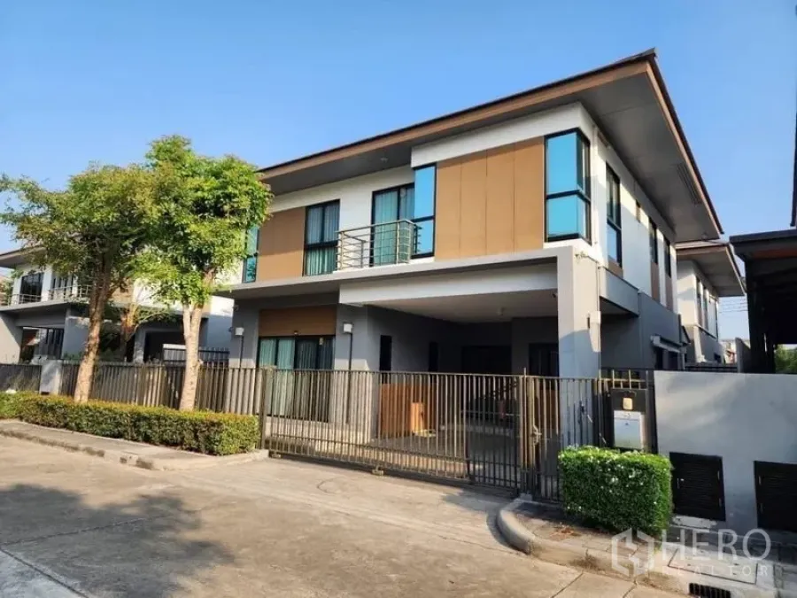 Detached House for rent in Prawet, Bangkok - Modern two-storey detached house with balcony, gated carport and tree-lined street.