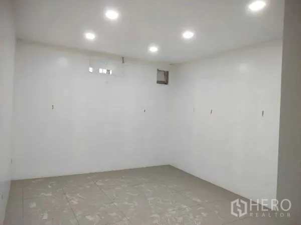 Shophouse for sale in Phra Khanong, Bangkok - Bright white room with recessed LED lights and tiled flooring.