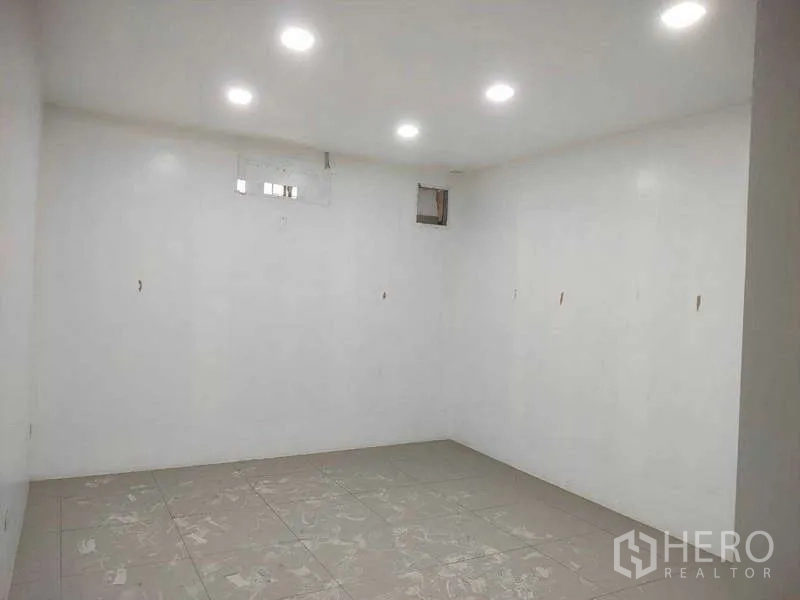 Shophouse for sale in Phra Khanong, Bangkok - Bright white room with recessed LED lights and tiled flooring.
