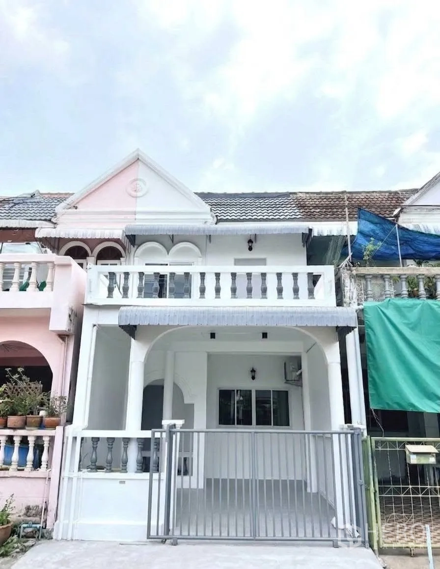 Townhouse for rent in Phra Khanong, Bangkok - Two-storey townhouse exterior with white facade, balcony railings and a front gate.