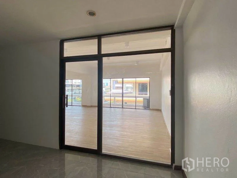 Office Space for rent in Watthana, Bangkok - Framed glass entrance to the office revealing the light-filled open plan beyond.