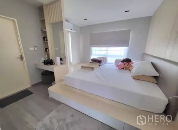 Townhouse for rent in Bang Phli, Samut Prakan - Master bedroom with platform bed, dressing table and soft natural light.
