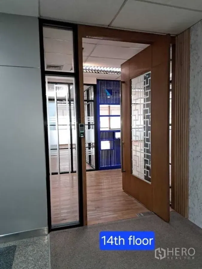 Office Space for rent in Bang Rak, Bangkok - Hallway view into the 14th‑floor office through a decorative wooden and glass door.