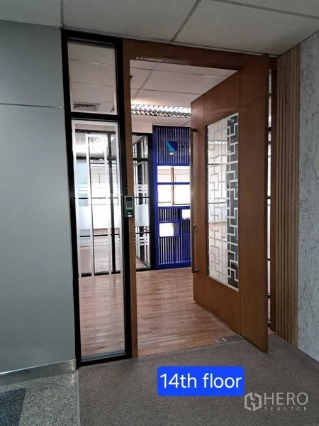 Office Space for rent in Bang Rak, Bangkok - Hallway view into the 14th‑floor office through a decorative wooden and glass door.