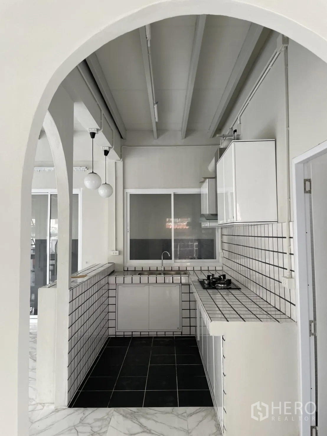 Detached House for rent or sale in Din Daeng, Bangkok - Built-in kitchen with arched entry, tiled countertops and pendant lights.