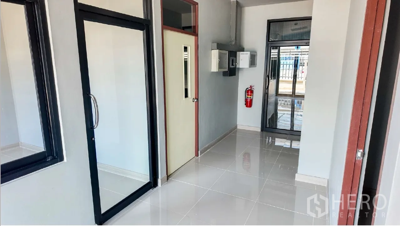仓库 for rent in Mueang Chon Buri, Chon Buri - 入口走廊设玻璃门、配电箱与壁挂式灭火器。
