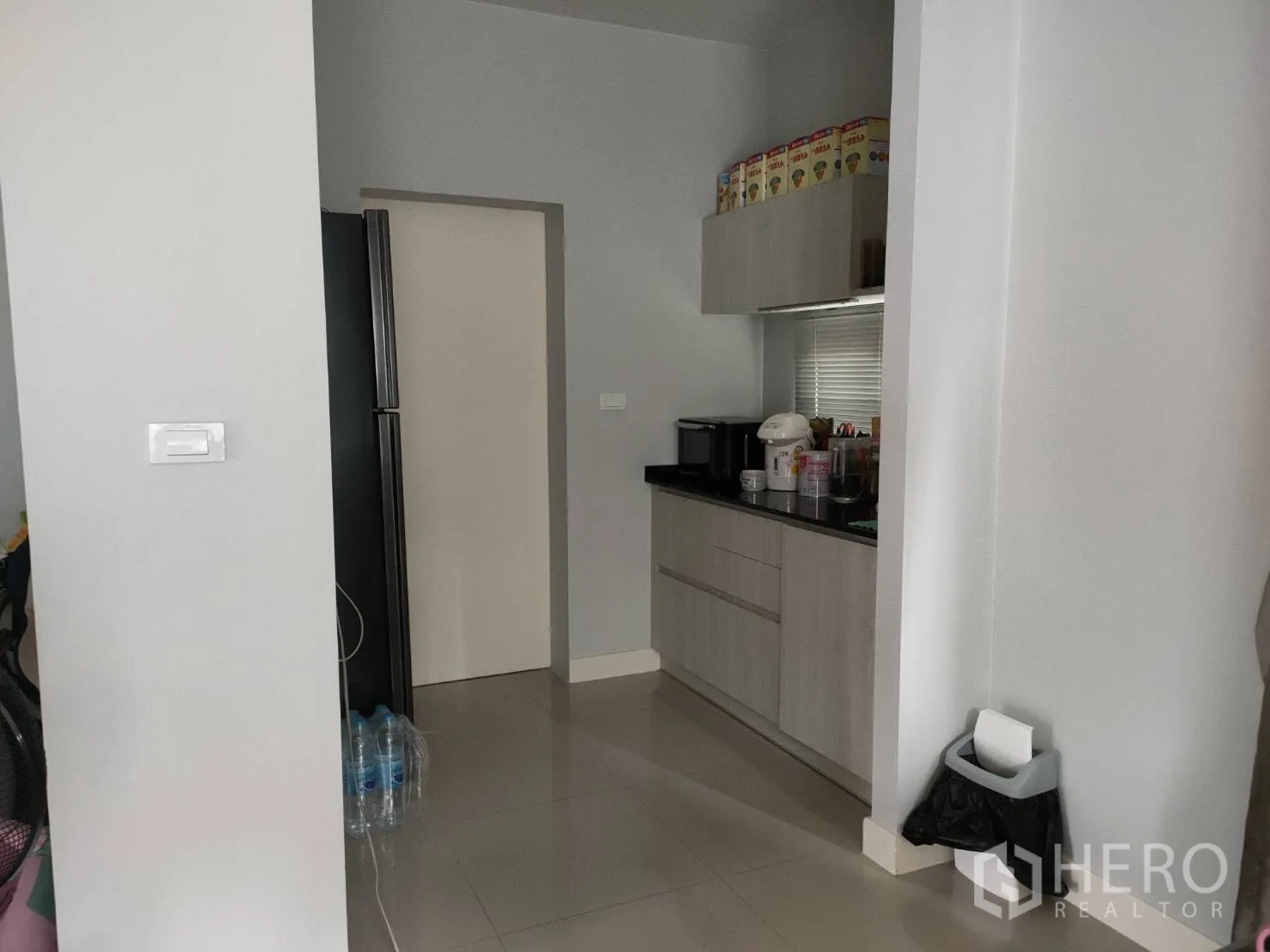 Detached House for rent or sale in Lam Luk Ka, Pathum Thani - Compact pantry with upper cabinets and black countertop next to the fridge alcove.