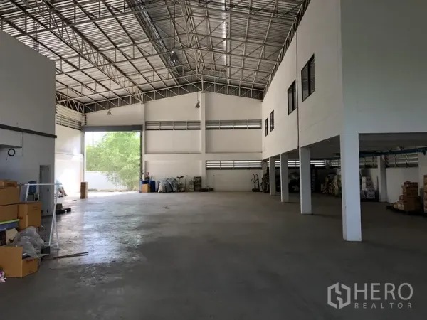 工厂 出租或出售在Lat Lum Kaeo, Pathum Thani - 宽敞仓库内景，高钢桁架屋顶与光滑混凝土地面。