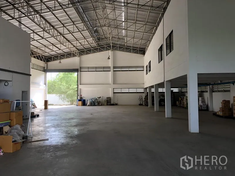 工厂 出租或出售在Lat Lum Kaeo, Pathum Thani - 宽敞仓库内景，高钢桁架屋顶与光滑混凝土地面。