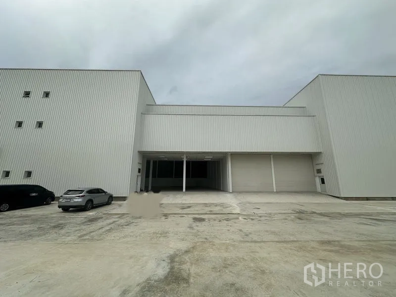 Factory for rent in Pathum Thani - Front loading bays with covered canopy and multiple roll-up doors at the factory.