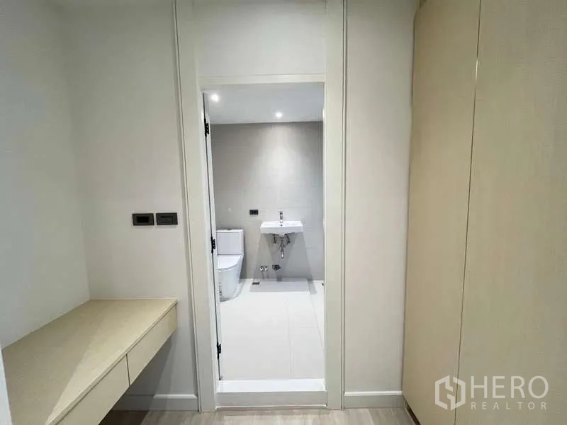 Townhouse for sale in Khlong Toei, Bangkok - Dressing area with built-in counter leading into an ensuite bathroom.