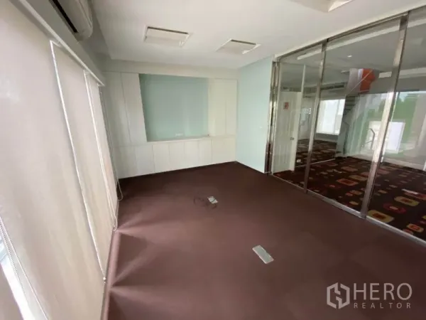 Home Office for rent in Wang Thonglang, Bangkok - Carpeted office space with glass sliding partitions, white cabinetry and blinds.