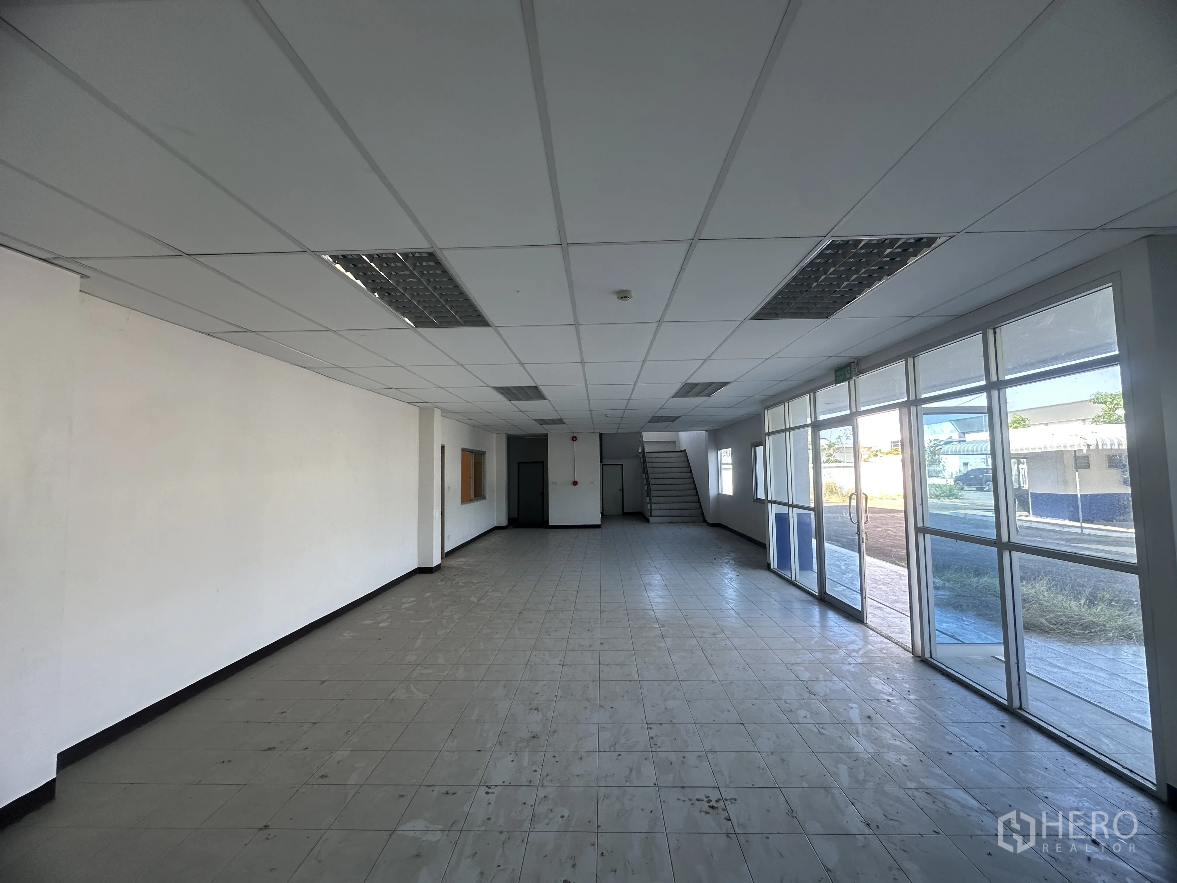 Factory for rent in Bang Pa-in, Phra Nakhon Si Ayutthaya - Ground‑floor office lobby with tiled floor, glass entrance wall, and staircase to the upper level.
