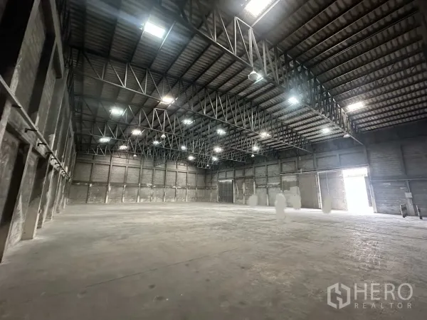 Warehouse for rent in Phra Nakhon Si Ayutthaya - Spacious warehouse interior with high steel truss roof and concrete floor.