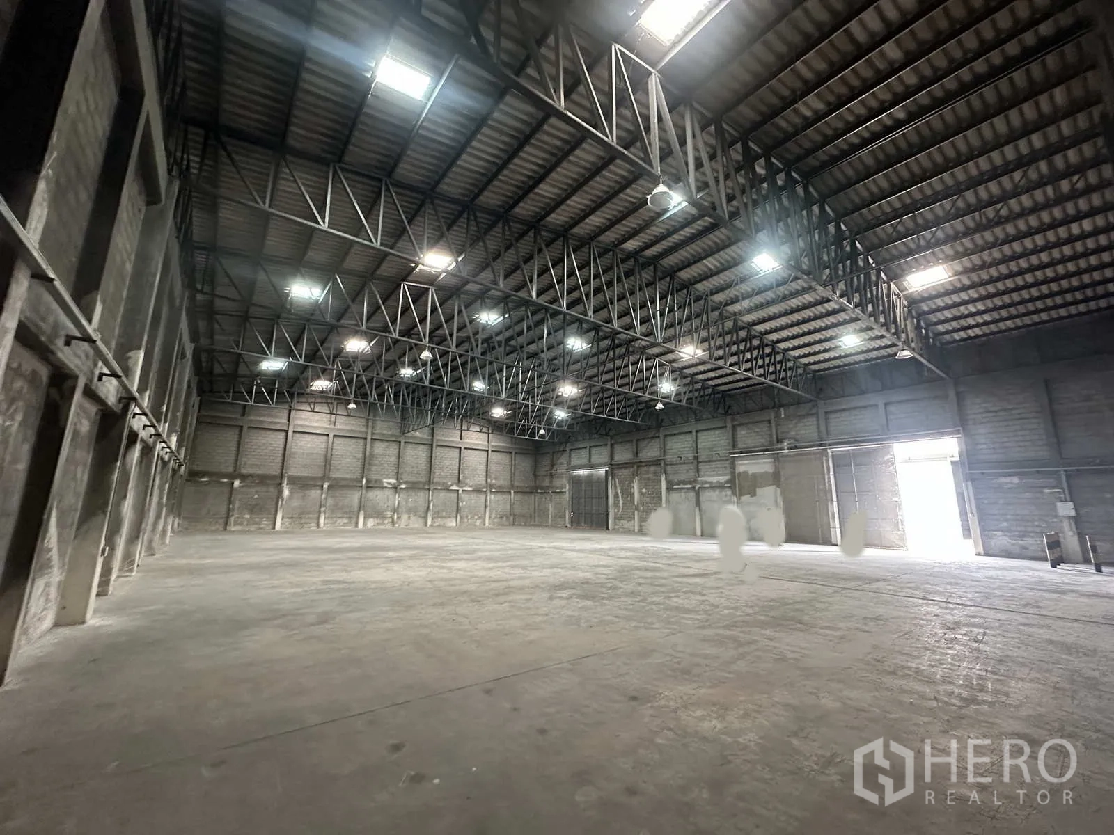 Warehouse for rent in Phra Nakhon Si Ayutthaya - Spacious warehouse interior with high steel truss roof and concrete floor.