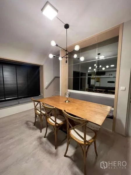 Detached House for rent in Prawet, Bangkok - Dining space with modern chandelier and bench seating by the window.