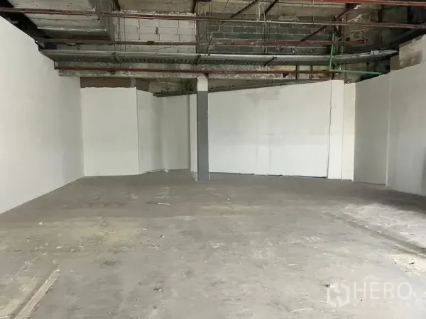 Retail Space for rent in Khlong Toei, Bangkok - Wide shell unit featuring smooth white walls and a pillar, ready for tenant fit-out.