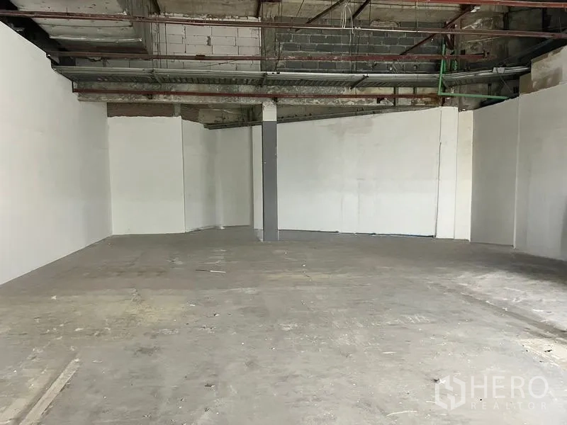 Retail Space for rent in Khlong Toei, Bangkok - Wide shell unit featuring smooth white walls and a pillar, ready for tenant fit-out.