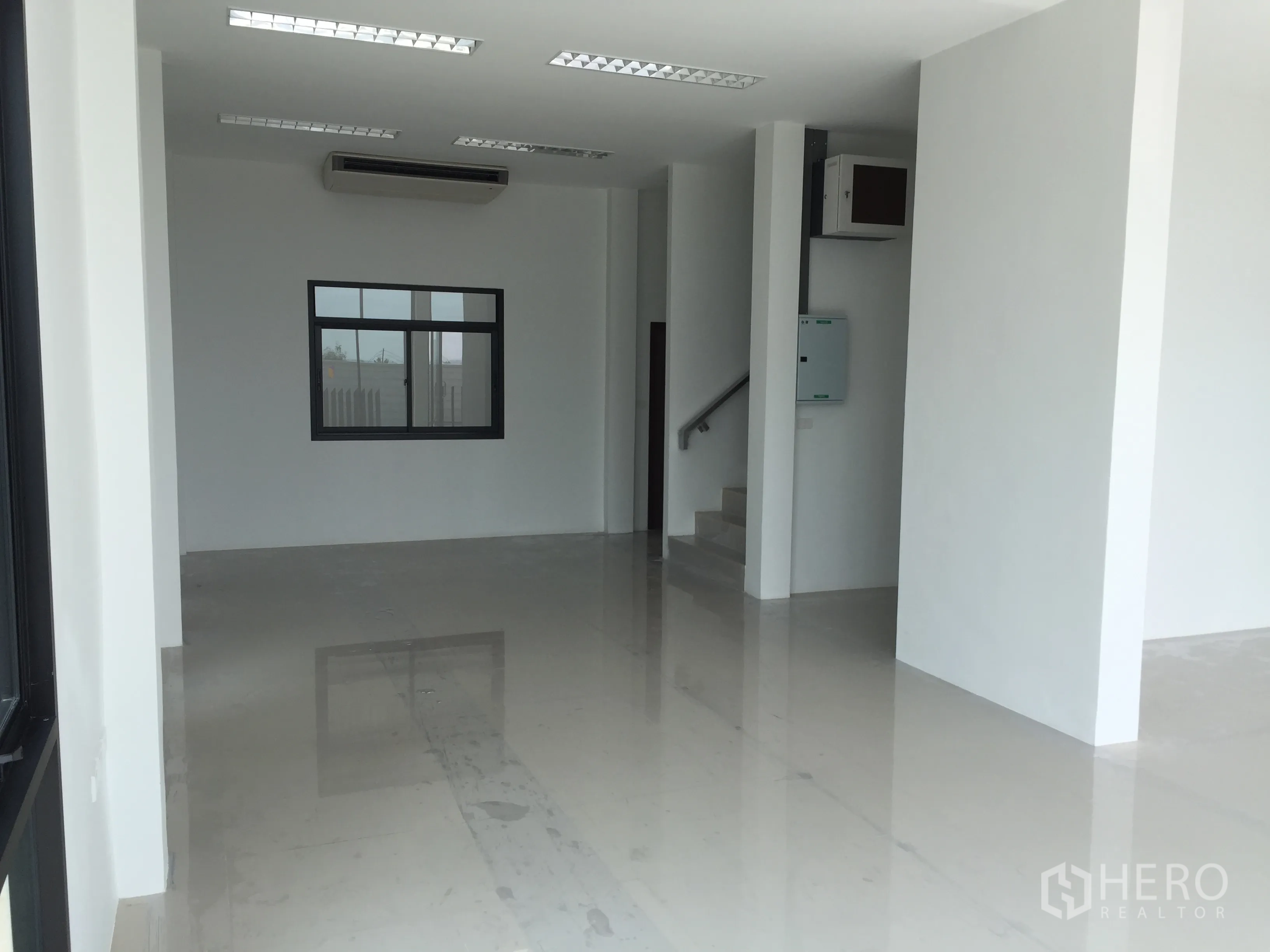 Factory for sale in Lam Luk Ka, Pathum Thani - Bright ground-floor office with polished tiles, AC unit and staircase.