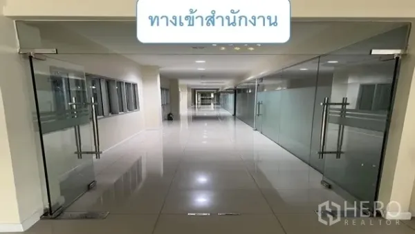 Warehouse for rent in Mueang Pathum Thani, Pathum Thani - Corridor with glass office entrances and polished floors inside the administrative building.