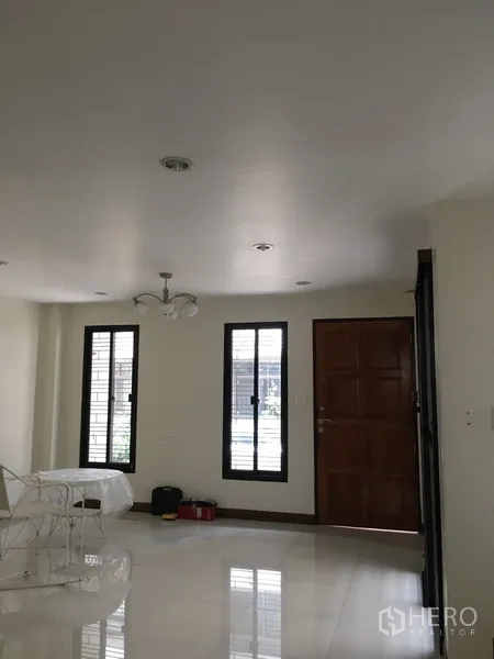 Home Office for rent in Bang Rak, Bangkok - Bright ground-floor lobby with glossy tiles, two tall windows and a solid wooden entry door.