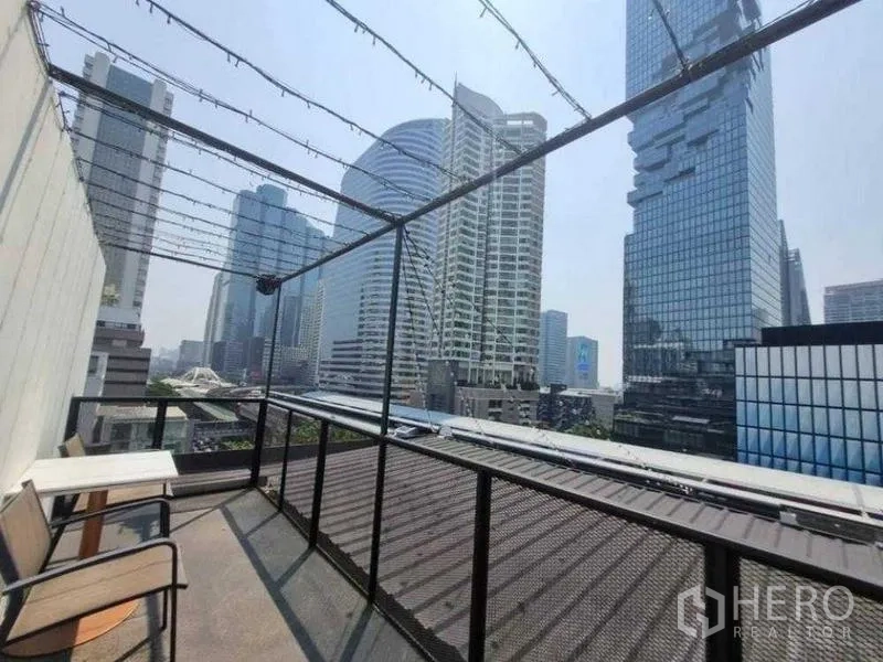 Retail Space for rent in Bang Rak, Bangkok - Upper terrace with canopy string lights and bench seating overlooking skyline.