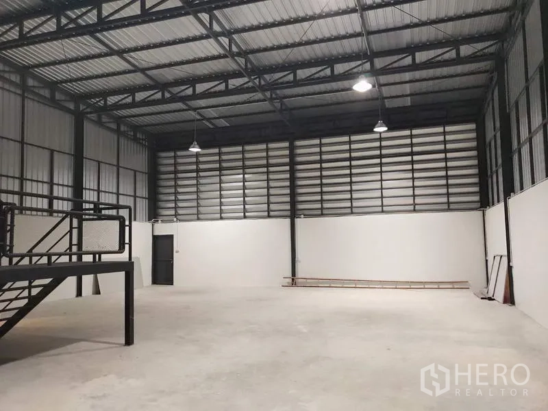 Factory for rent in Lam Luk Ka, Pathum Thani - Clean industrial hall with insulated roof panels and mezzanine platform for storage or work.
