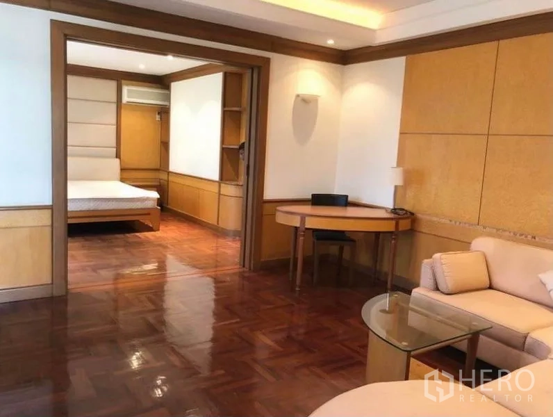 Detached House for sale in Mueang Samut Prakan, Samut Prakan - Large suite with sitting area, desk and doorway to a bedroom with parquet floors.