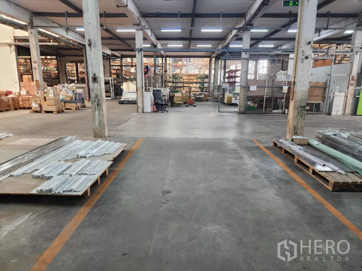 Factory for rent in Mueang Samut Sakhon, Samut Sakhon - Industrial storage zone with columns, racking and materials on pallets.