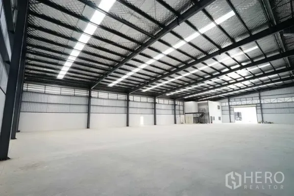 Factory for rent in Chon Buri - Clear-span warehouse hall with bright natural light and internal office block.
