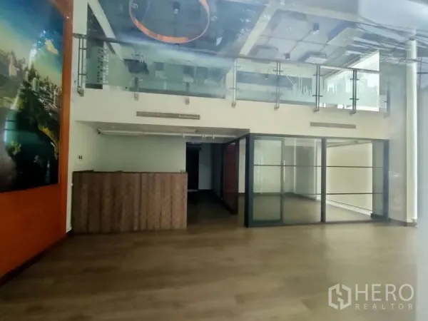 Office Space for rent in Pathum Wan, Bangkok - Loft-style office interior with mezzanine, glass railings, wood flooring, reception counter, and a glass-partitioned meeting room.