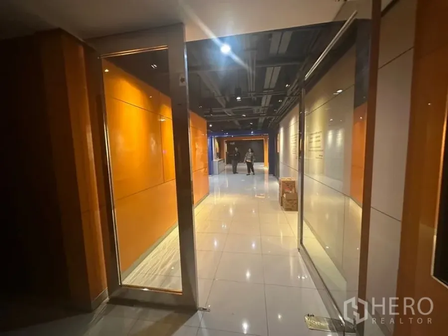 Office Space for rent in Khlong Toei, Bangkok - Polished tile corridor with orange wall panels and glass doors leading to office suites.