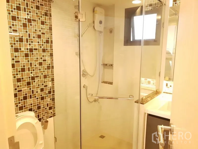 Detached House for rent in Bang Kapi, Bangkok - Bathroom with glass-enclosed shower, mosaic accent tiles, and water heater.