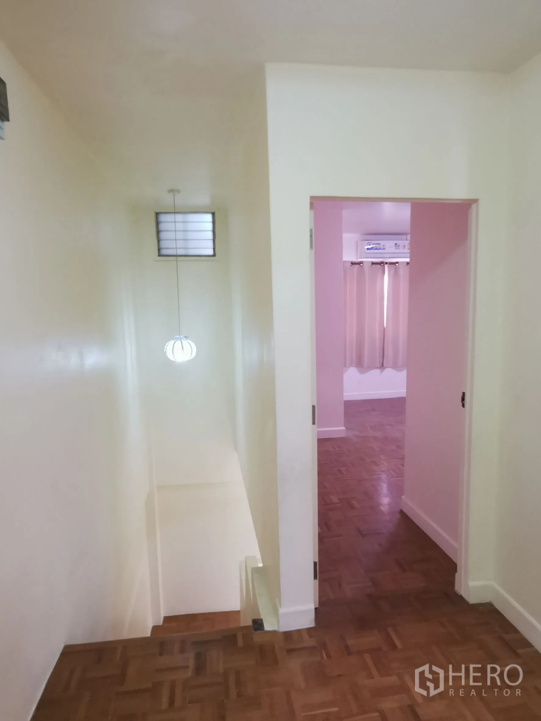 Townhouse for rent in Khlong Toei, Bangkok - Upper hallway with wooden floor leading to a bedroom and stairwell.