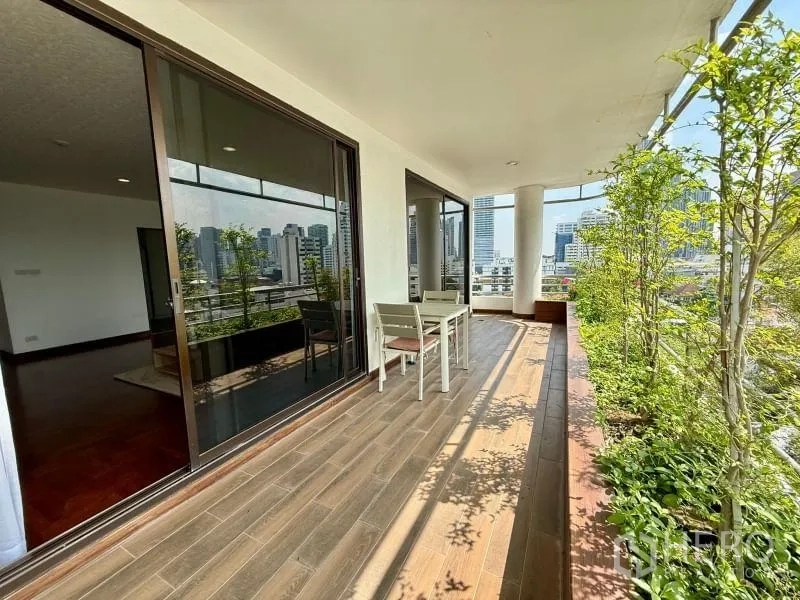 Condominium for rent - Balcony seating area outside sliding doors lined with lush planters.