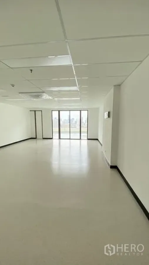 Office Space for rent in Watthana, Bangkok - Bright open-plan office interior showing ceiling panels and wide glazed doors to the view.