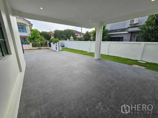 Detached House for sale in Thanyaburi, Pathum Thani - Spacious covered carport and terrace facing the gated front yard.