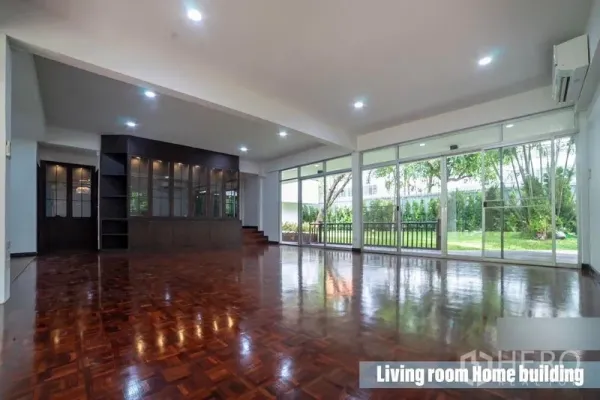 Home Office for rent in Khlong Toei, Bangkok - Spacious living area with polished parquet flooring and floor-to-ceiling sliding glass doors to the garden.