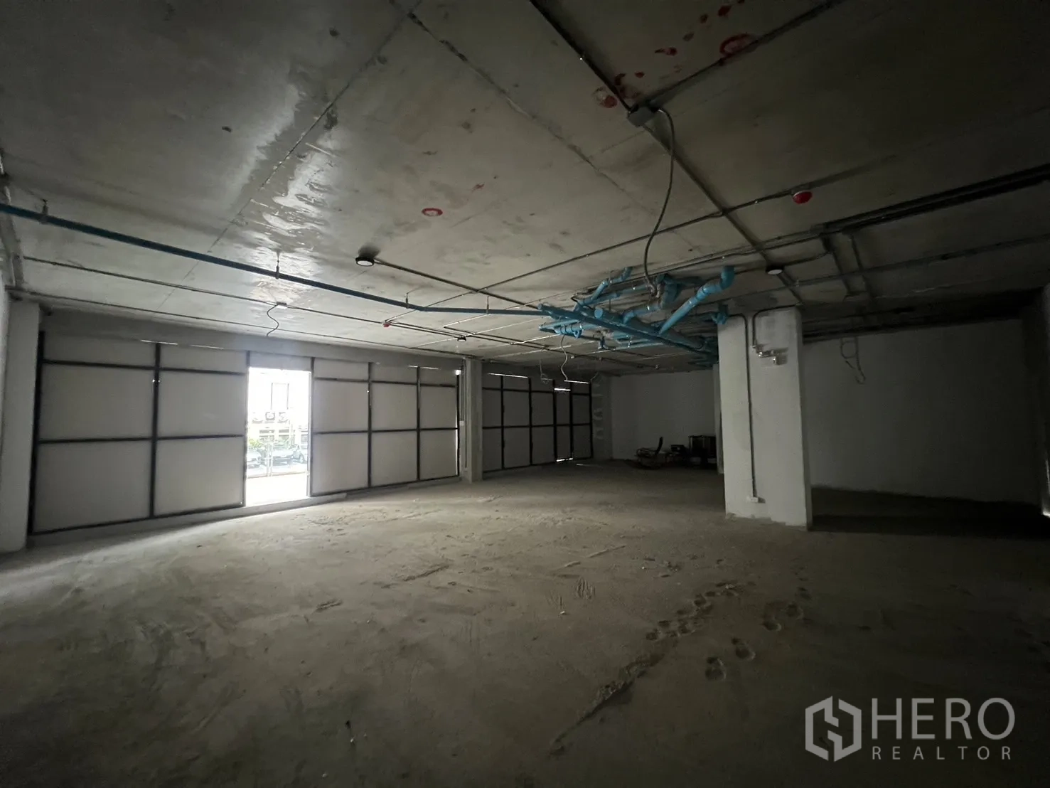 Retail Space for rent - Spacious interior bay with roller-style frontage and service door allowing natural light.