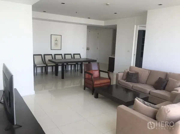 Condominium for rent in Pathum Wan, Bangkok - Spacious open-plan living and dining room with sofa set, coffee table and long dining table.