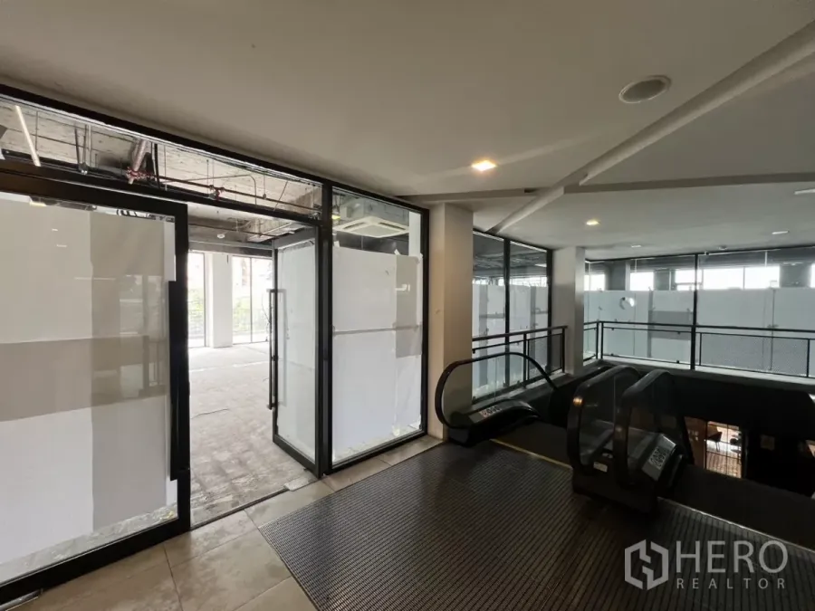 Retail Space for rent in Watthana, Bangkok - Second-floor retail entrance with escalator access and glass storefront doors.