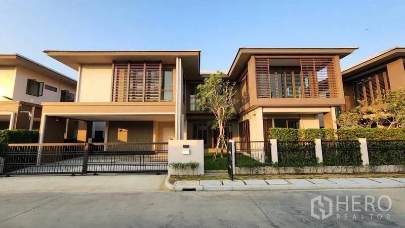 Detached House for rent or sale in Bang Kapi, Bangkok - Modern two‑storey detached house with wood louver facade, gated driveway and small garden on a quiet Bangkok street.