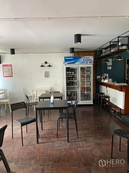 Home Office for rent in Pathum Wan, Bangkok - Open office area with tables, display fridge and bar counter under pendant lights.