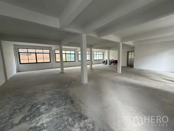 Office Space for rent in Bang Rak, Bangkok - Spacious unfurnished office area with rows of windows and lift access.