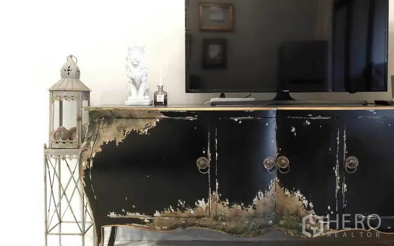 Townhouse for rent in Watthana, Bangkok - TV on a distressed black console cabinet with lantern decor.